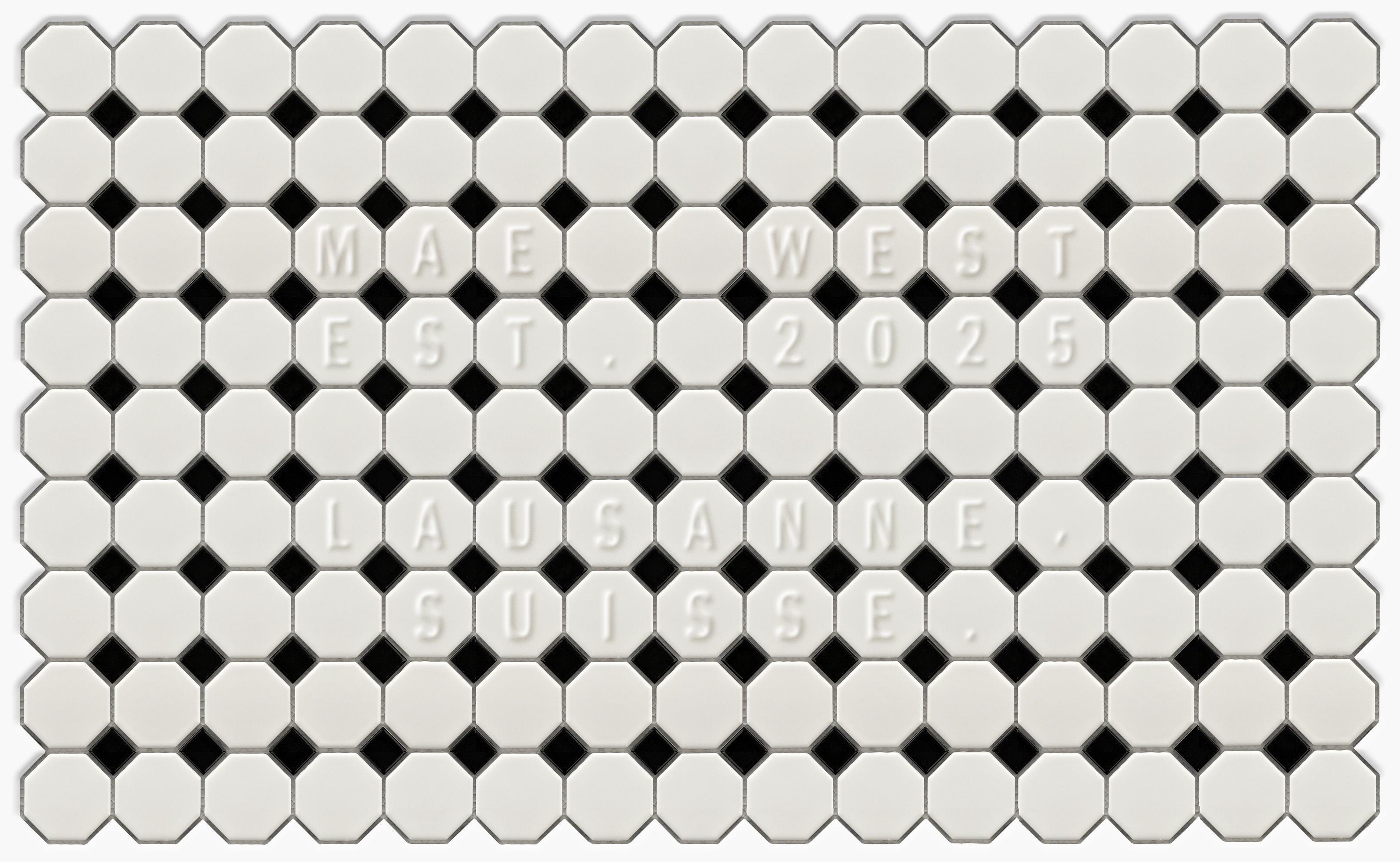 Black and white floor tiles with embossed letter reading: 'MAE WEST  EST. 2025  LAUSANNE, SUISSE.'